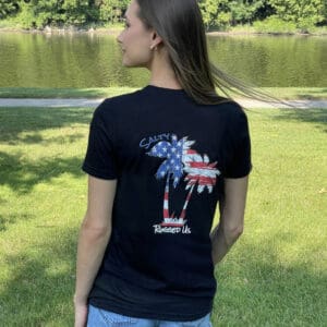 A woman standing in the grass wearing a black shirt.