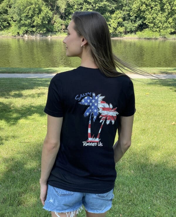 A woman standing in the grass wearing a black shirt.