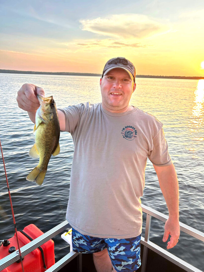 A man holding a fish on top of a boat.