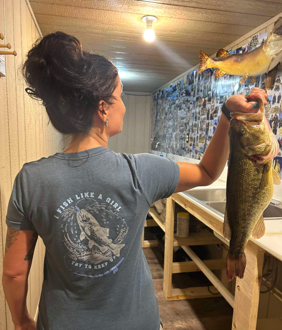 A woman holding a fish in her hand.